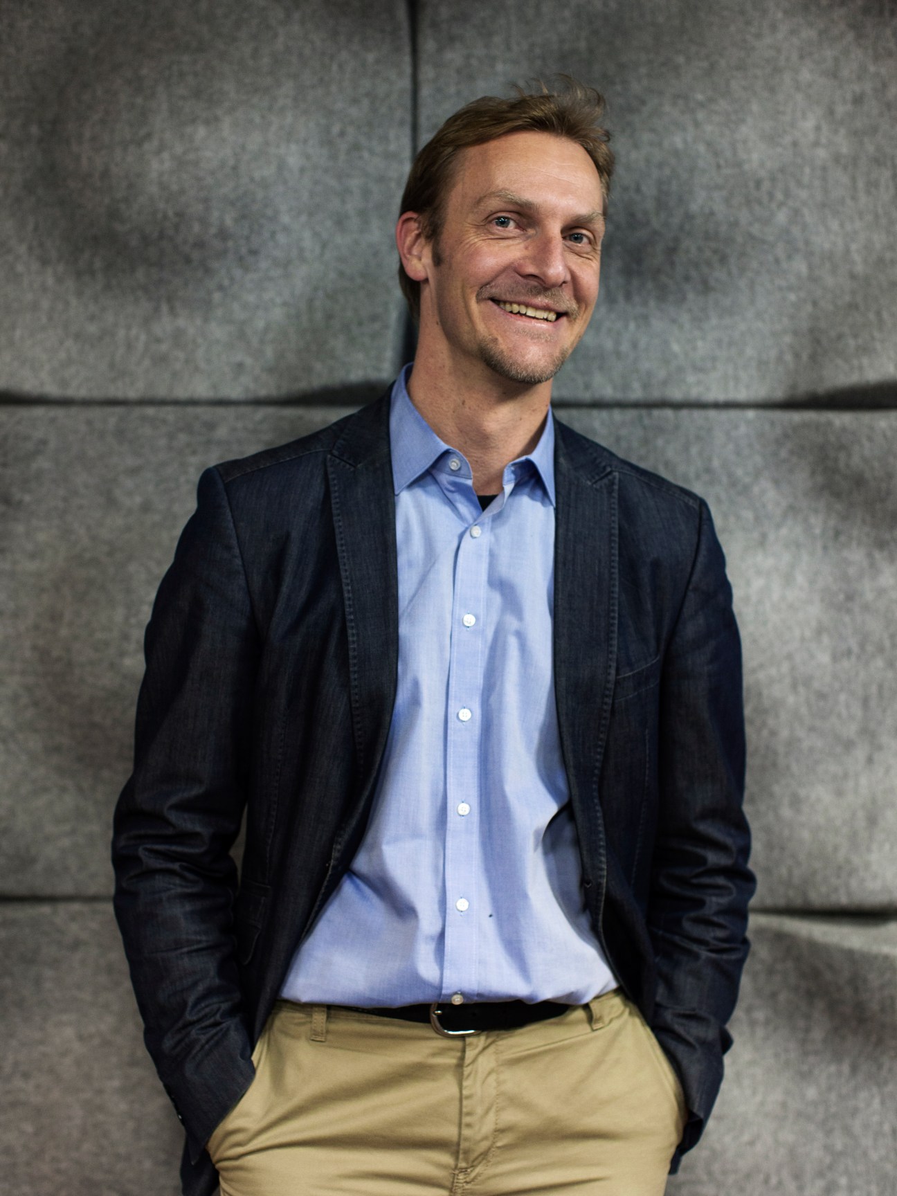 Marcus Schwedhelm, head of leisure coordination at the Migros Group, smiling in a blue shirt and navy blazer.