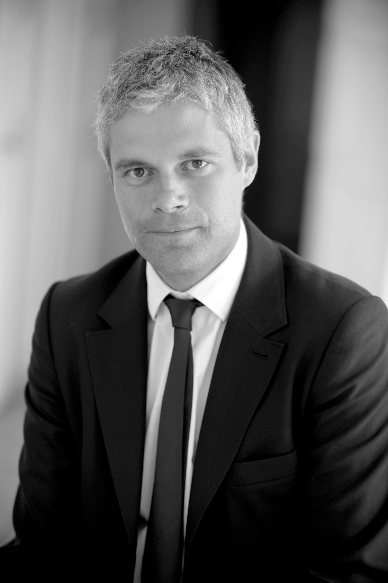 Black and white portrait of Laurent Wauquiez, France's Minister for Higher Education, wearing a dark suit and tie.