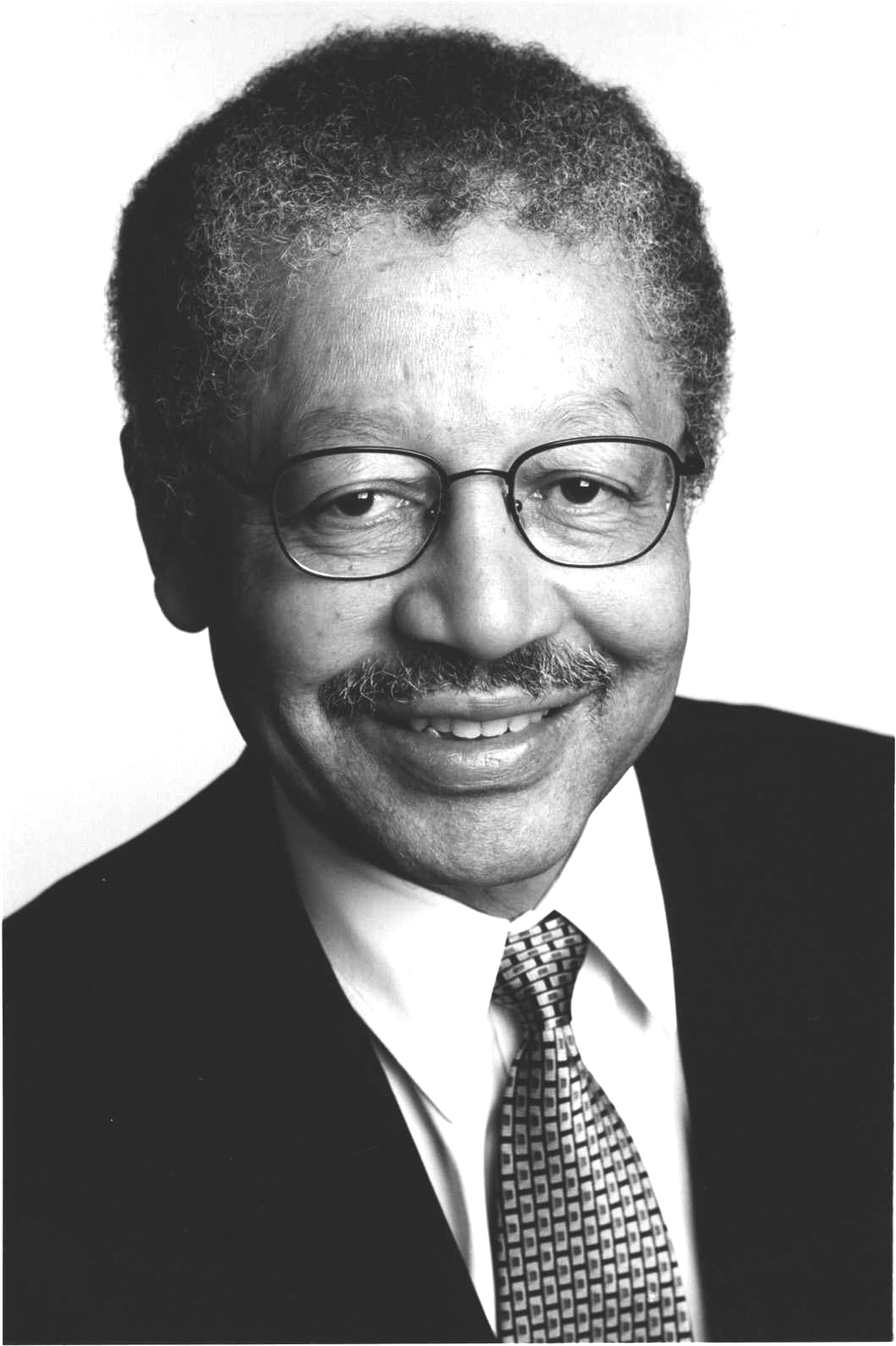 Portrait of Edward Blakely, urban policy expert, wearing glasses and dark suit with patterned tie.