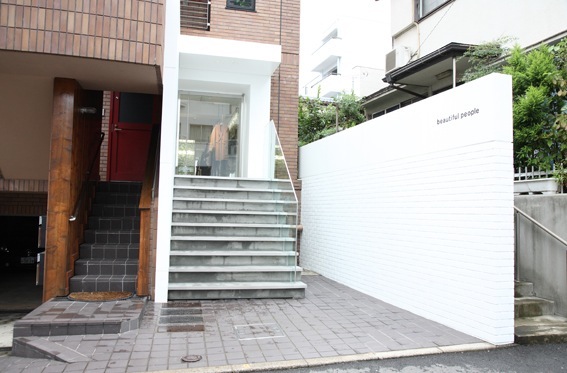 Exterior view of Beautiful People store in Tokyo with white walls, stepped entrance, and modern minimalist design.