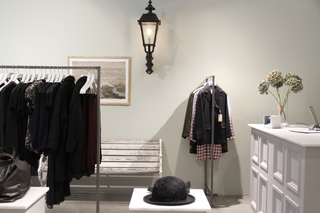 Interior of Nitty Gritty store in Stockholm displaying women's clothing on racks and a dress form with plaid details.