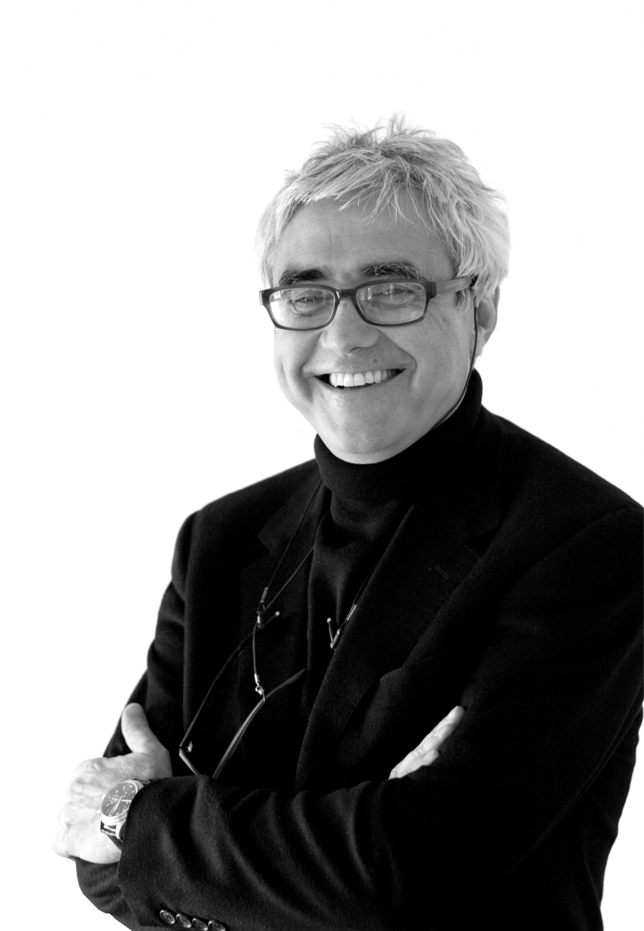 Black and white portrait of architect Rafael Vinoly wearing glasses and dark clothing against a white background.