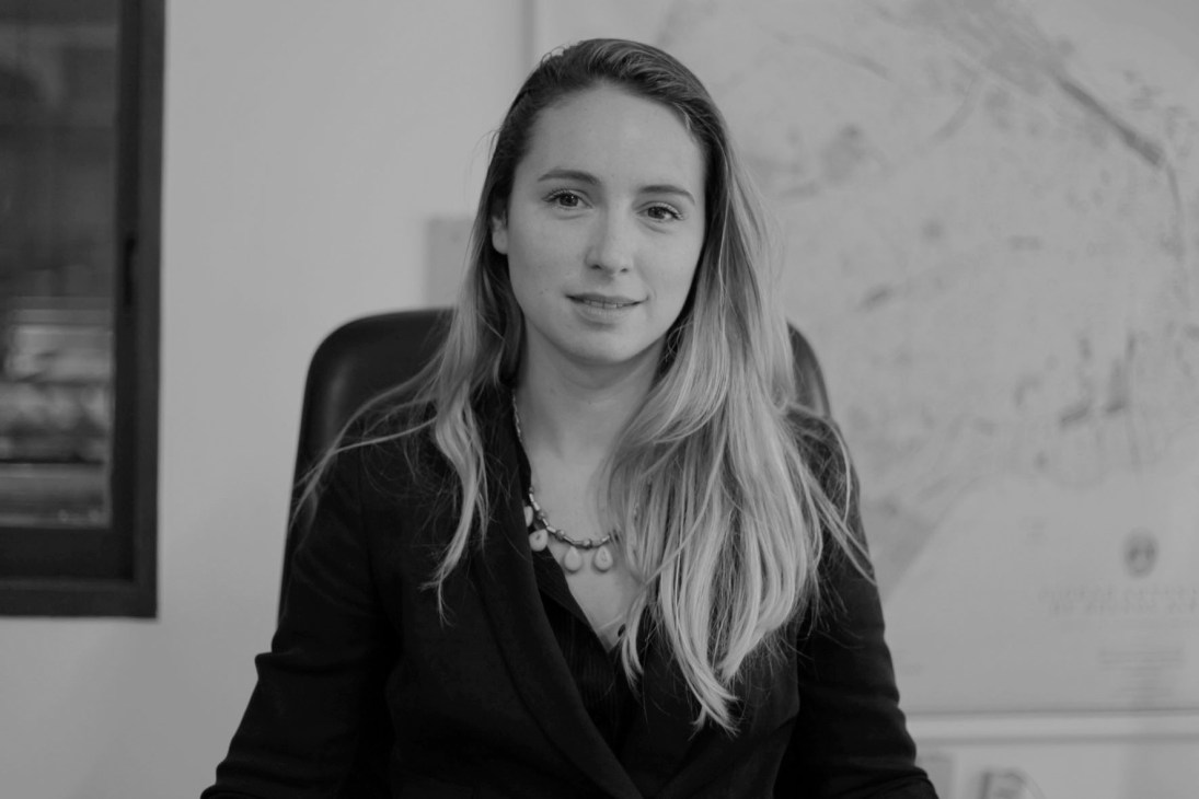 Black and white portrait of Paula Bisiau, director of Palermo Commune in Buenos Aires, wearing a dark blazer and necklace.