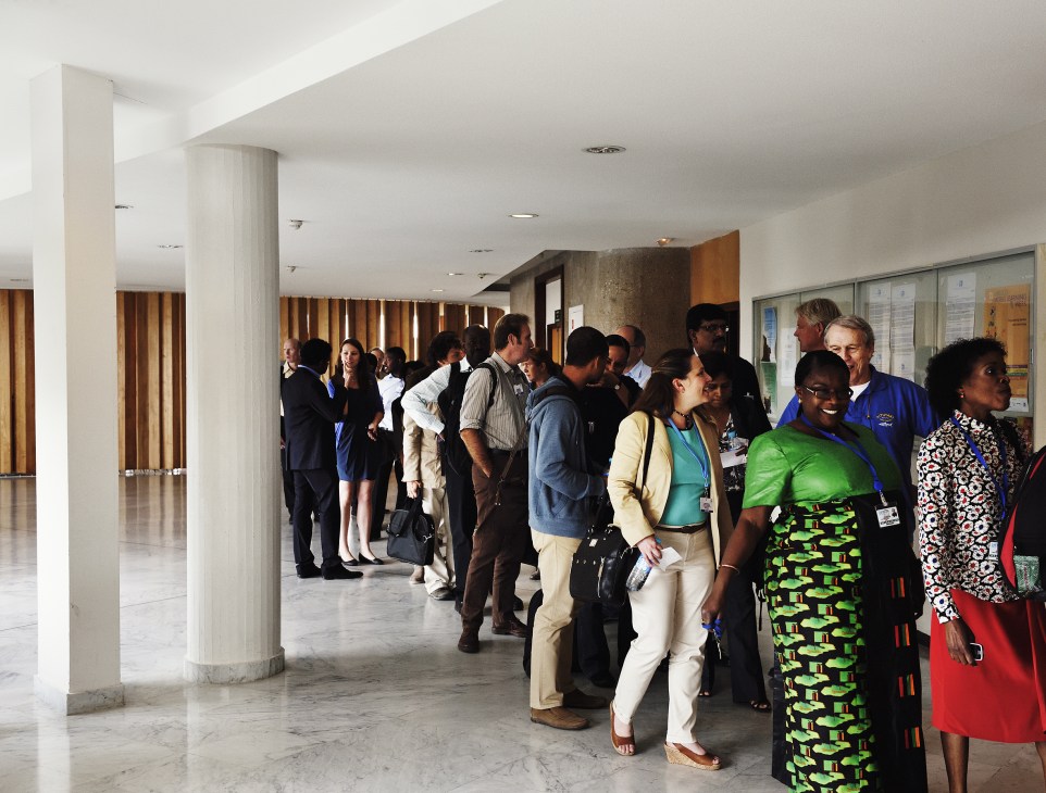 Queue of Unesco staff in a modernist corridor waiting for lunch at the seventh floor cafeteria.
