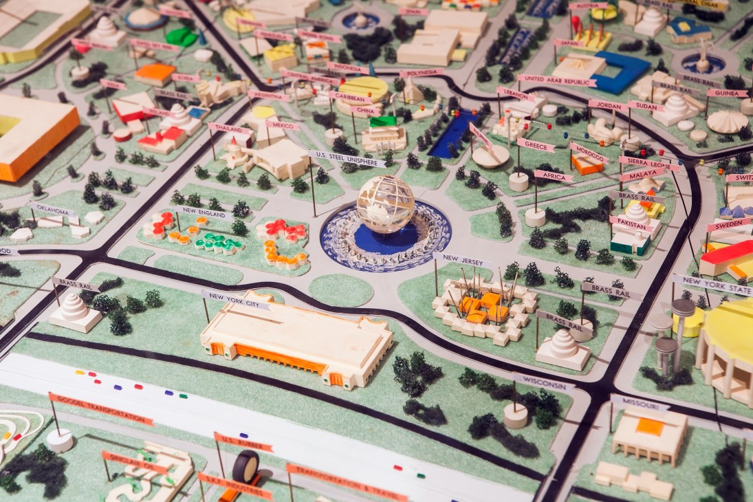 Detailed architectural model of the 1964 World's Fair site showing the Unisphere, pavilions, and country exhibits.