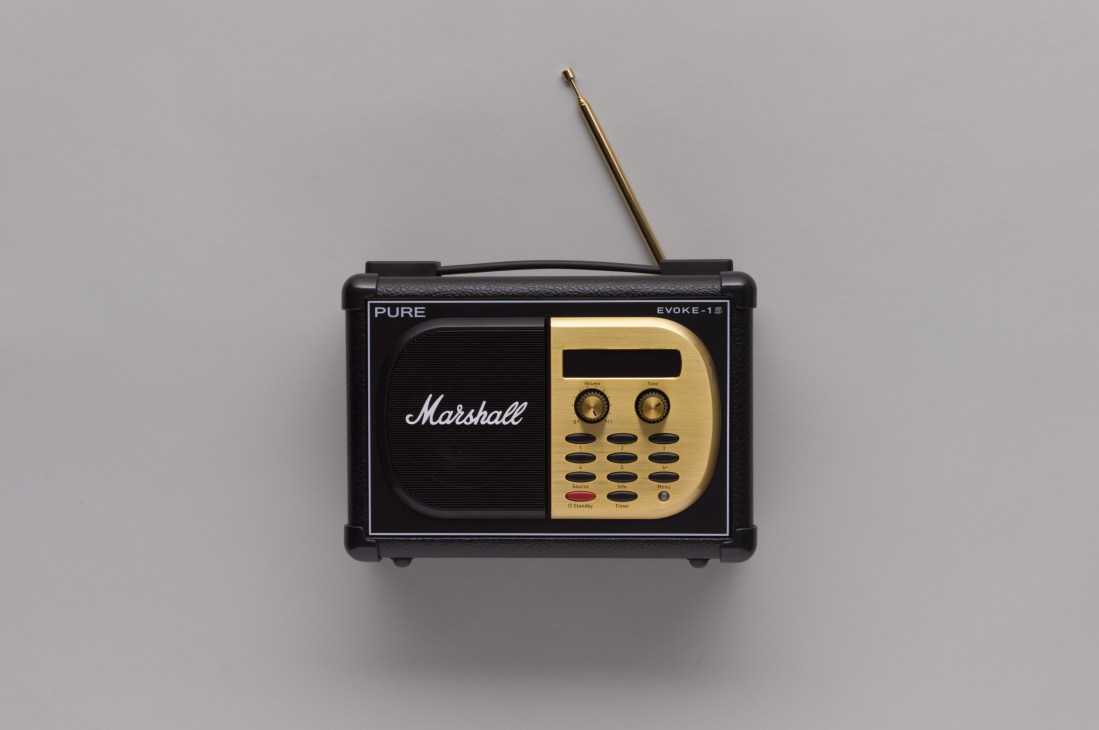 Black and gold Evoke-1S Marshall digital radio with extended antenna against gray background.