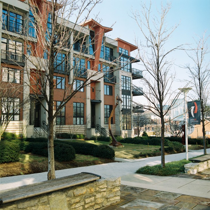 Modern apartment building with orange and tan brick exterior and blue window frames in downtown Chattanooga.