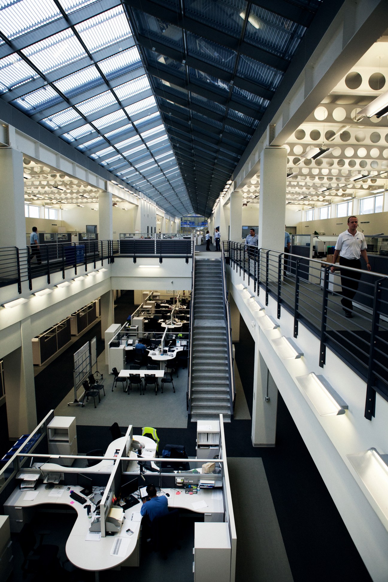 Interior of Volkswagen offices showing a modern multi-level workspace with natural light from skylights, white walls, and contemporary design elements.