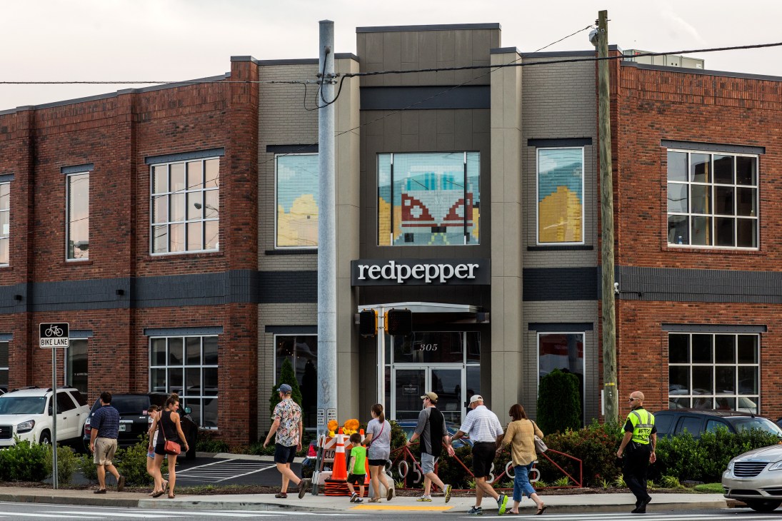 Redpepper branding agency storefront in Germantown with brick and stone facade, colorful window display, and pedestrians crossing street.