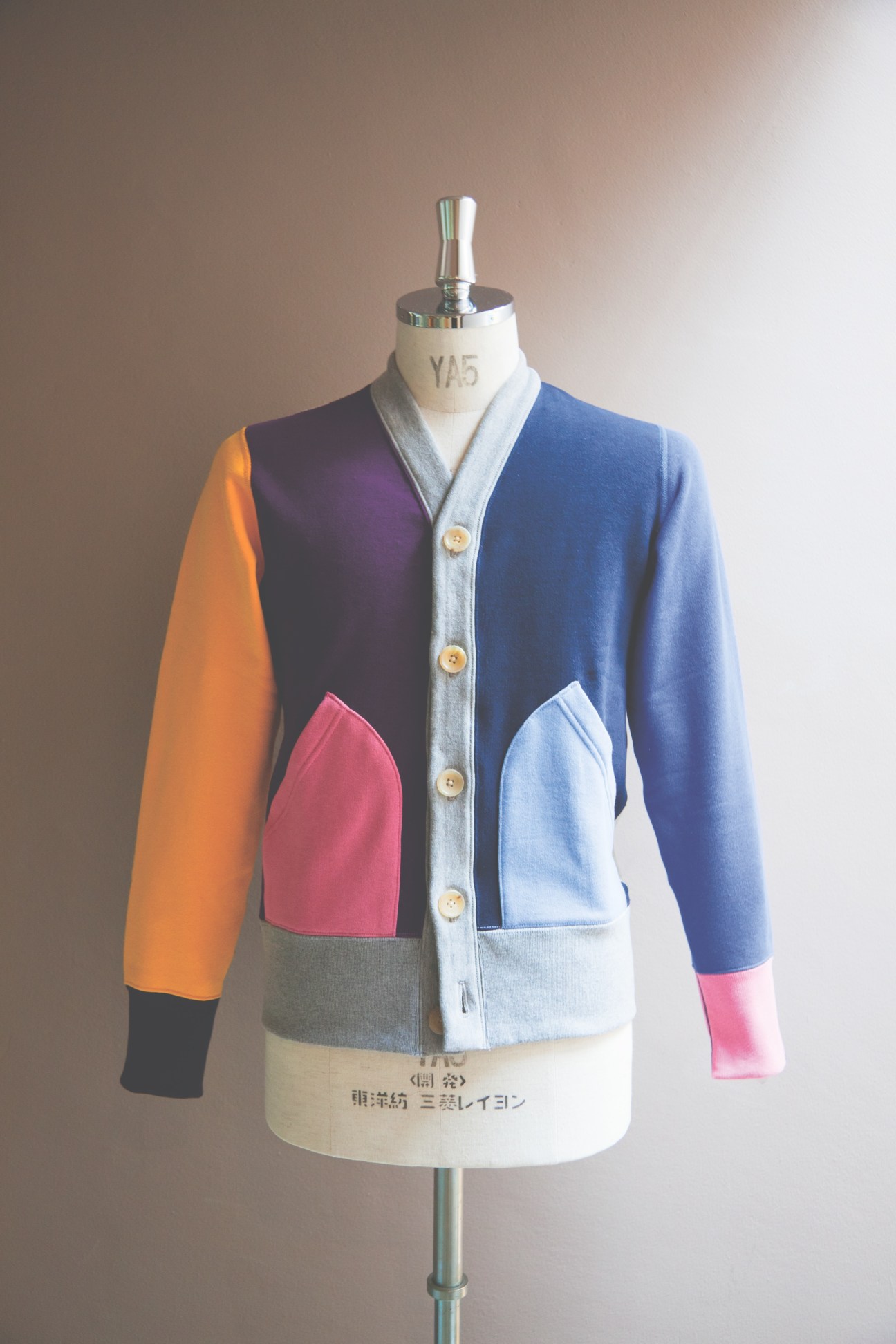 Colorful Loopwheeler cardigan on dress form with blue, orange, pink and gray color blocking.