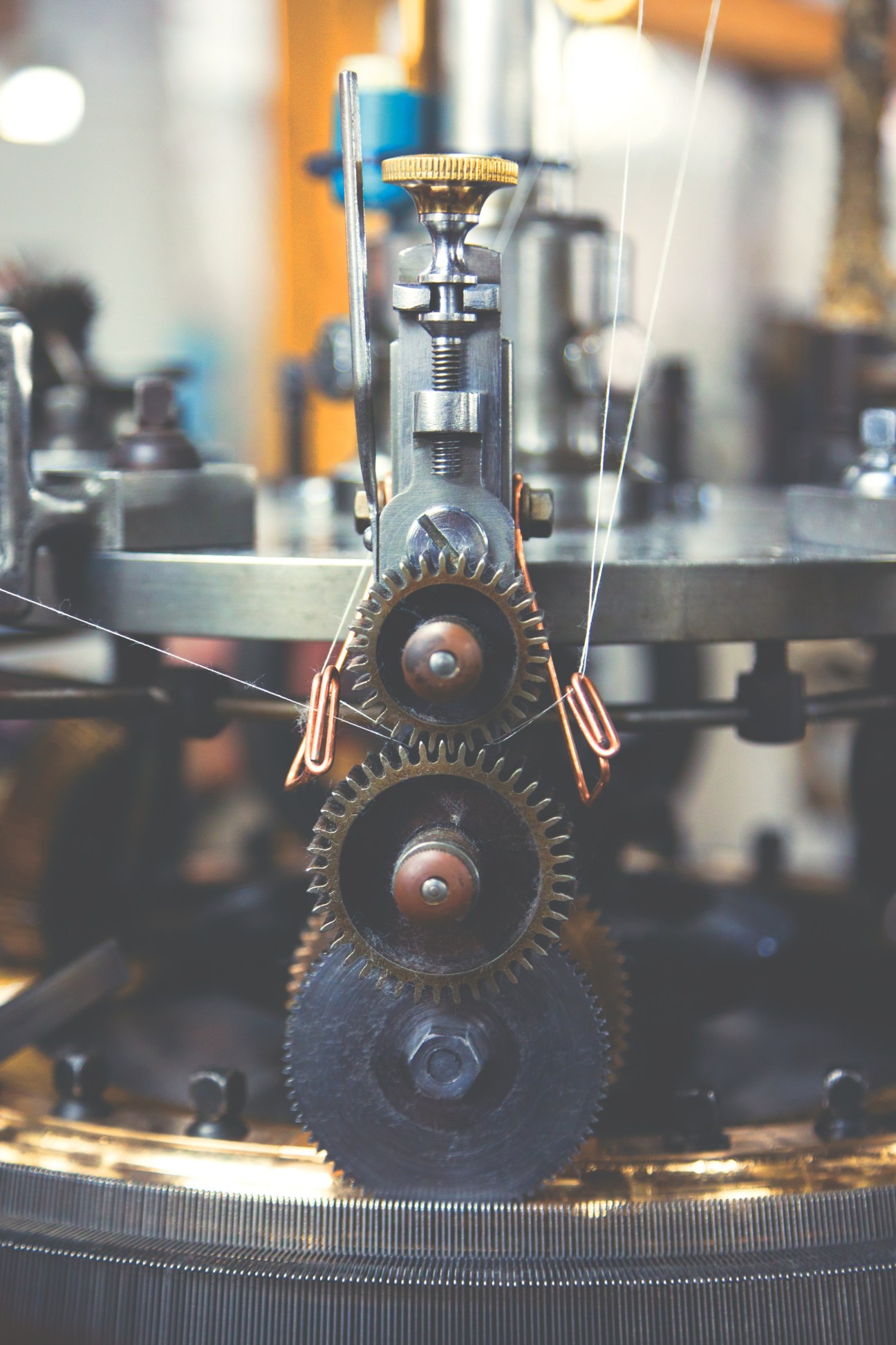 Close-up of loopwheel circular knitting machine gears and mechanical components with copper wire.