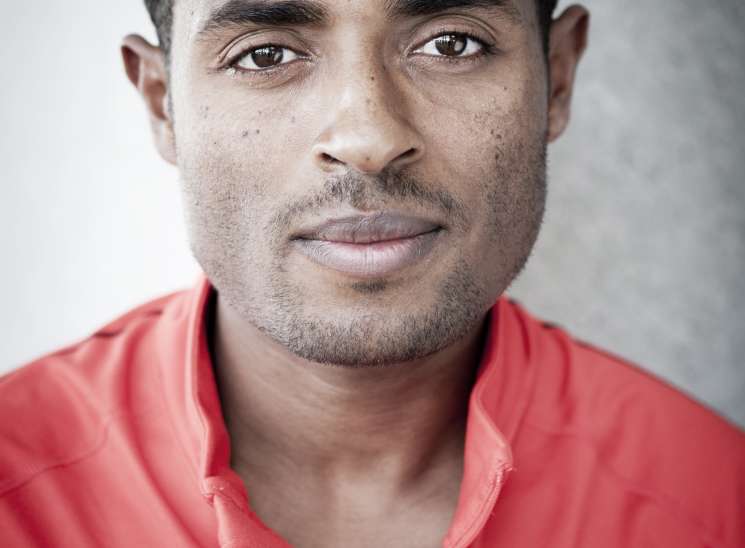 Portrait of Kenenisa Bekele, Ethiopian Olympic distance runner, wearing a red Nike jacket.
