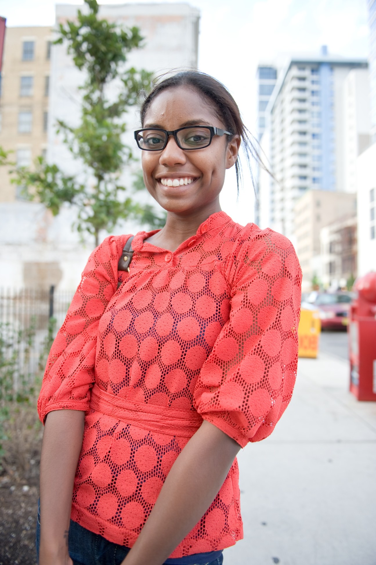 Kellie Few, a grad student, smiling on a South Loop street with residential buildings in the background.