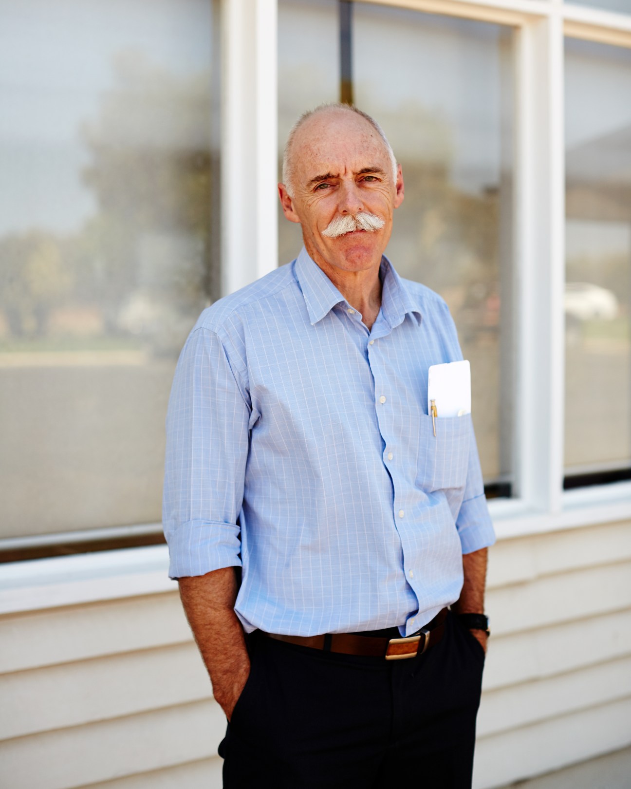 Andrew Cameron, director of nursing at Birdsville Health Clinic, stands in a light blue shirt outdoors.