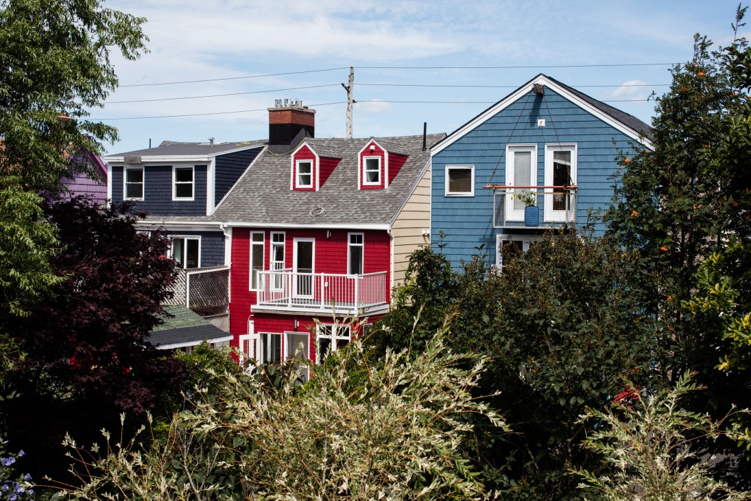 Colorful wooden houses including red and blue homes with white trim on Creighton Street
