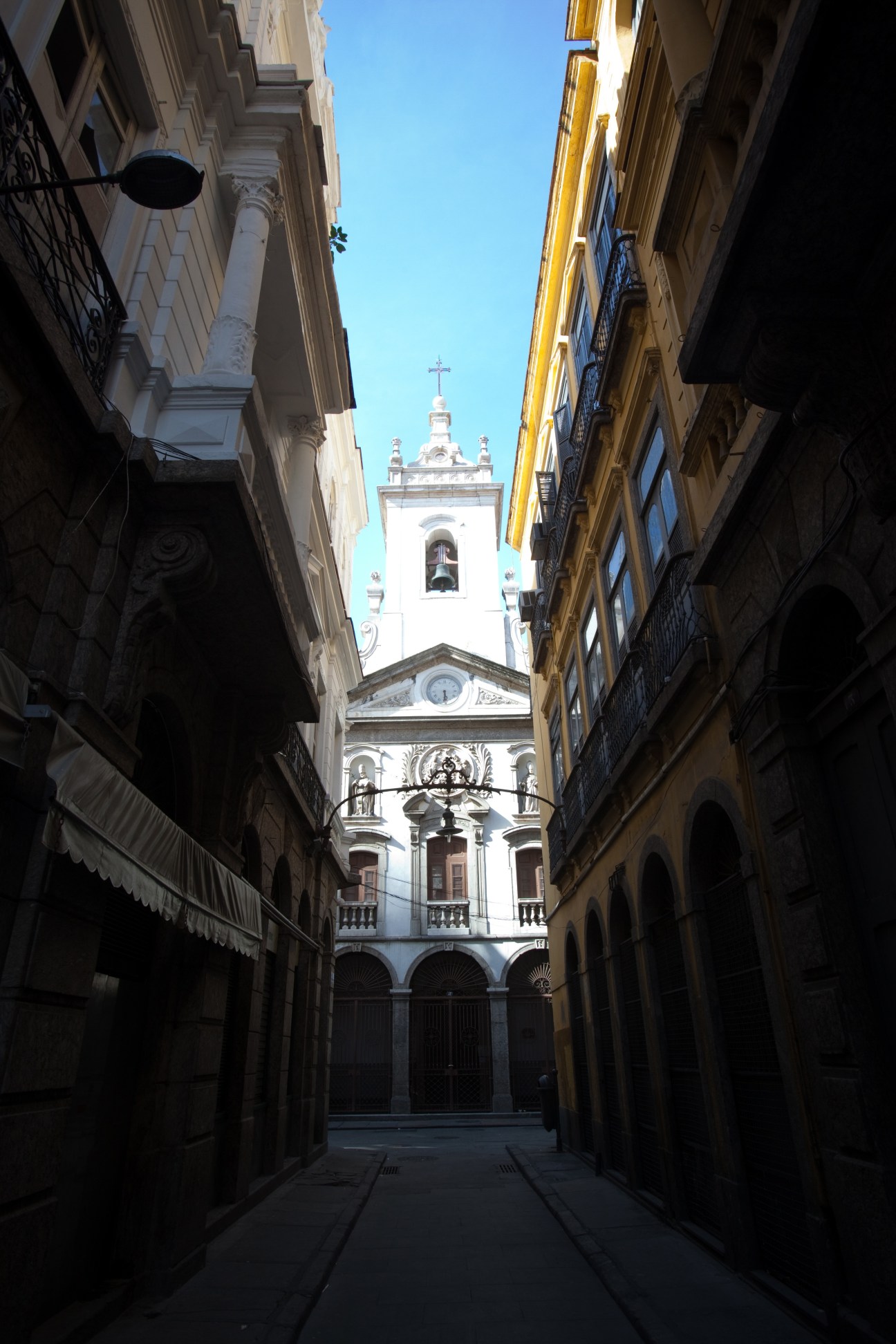 Church in rua do Mercado, Centro district, seen from a narrow cobblestone street lined with colonial buildings.