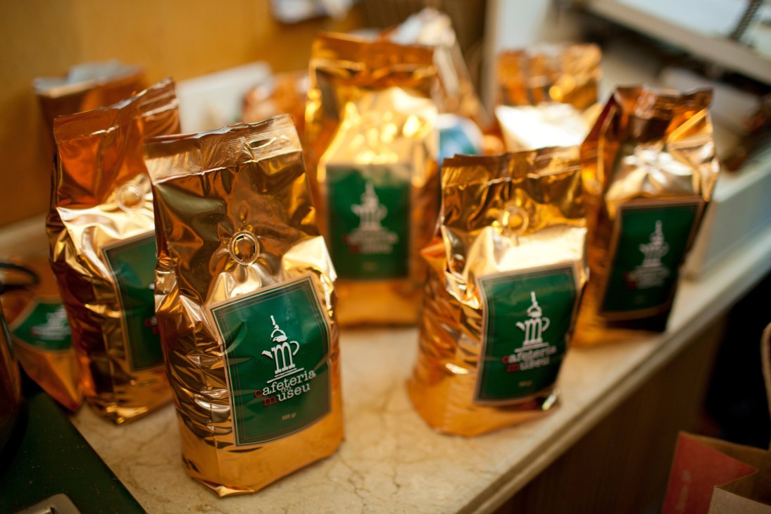 Gold foil coffee bags with green labels displayed on a counter at the Coffee Exchange.