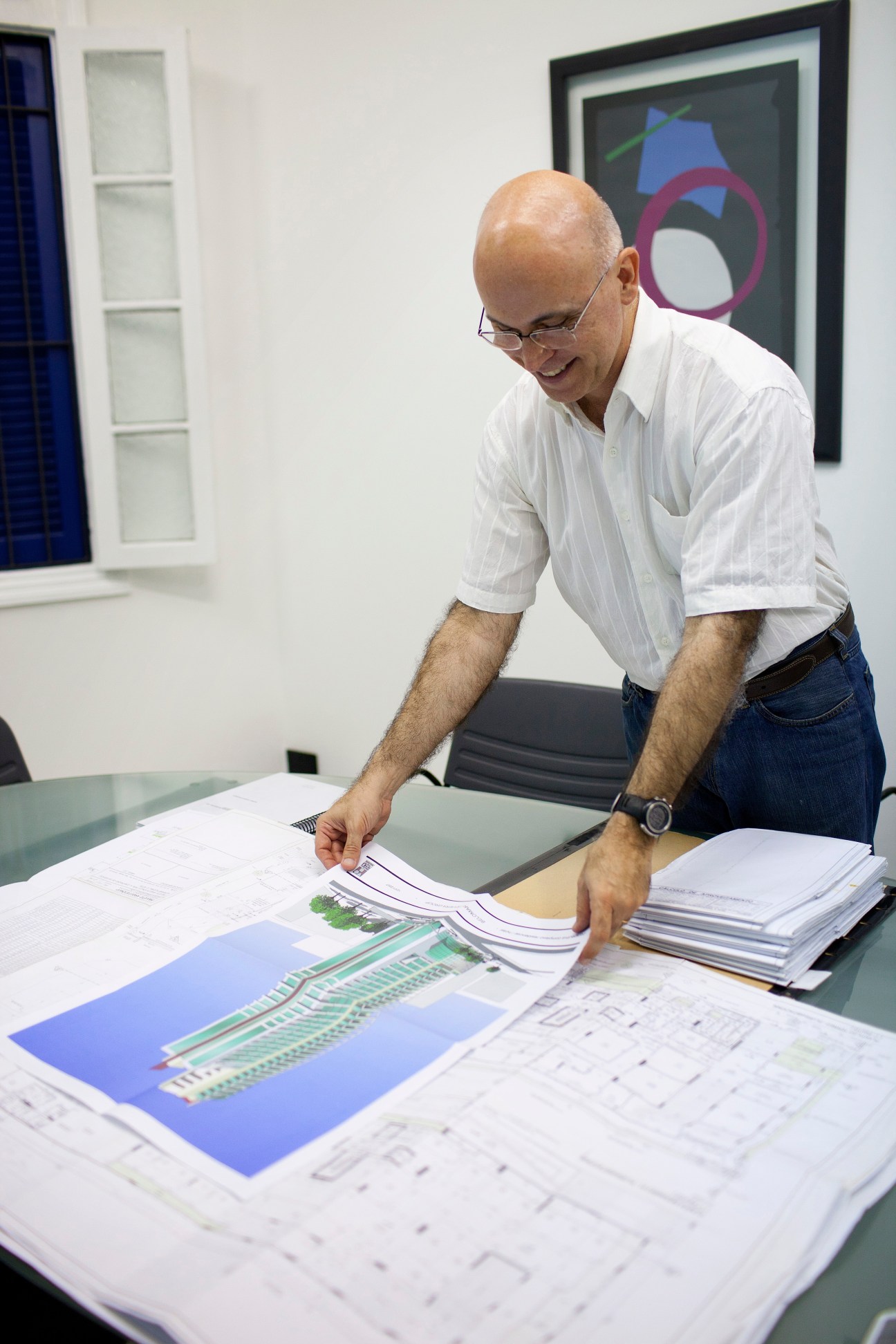 Daniel Proença, architect, reviewing architectural plans and blueprints at a table in his office.