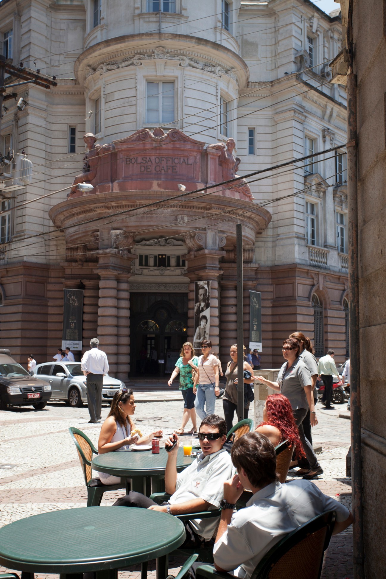Outdoor café seating in front of the historic Bolsa Oficial de Café building in Santos city centre.
