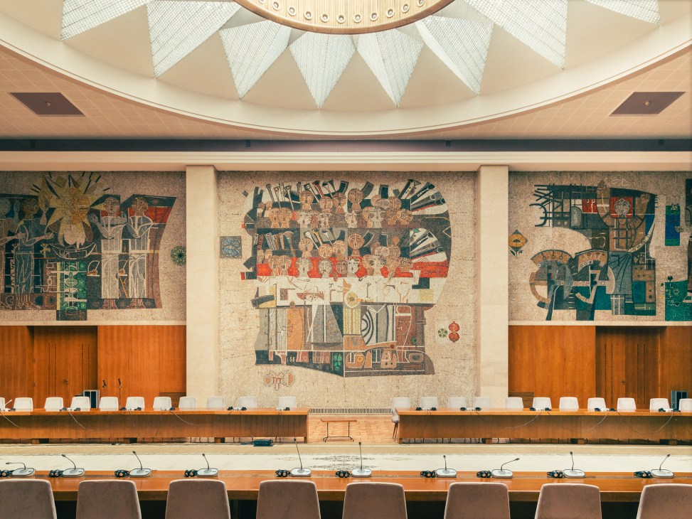 Hall of Yugoslavia with modernist dome ceiling, colorful expressionist mural by Lazar Vujaklija, and wooden desk setup.