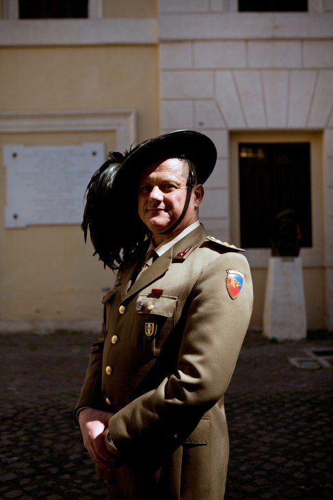 Guard in beige military uniform standing in front of a classical building facade at Porta Pia in Rome.