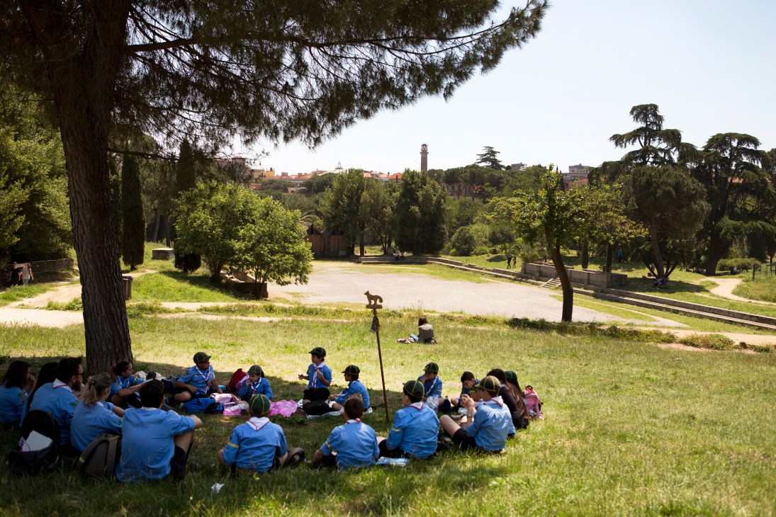 School group sitting on grass in Villa Torlonia park in Rome's Trieste neighbourhood.