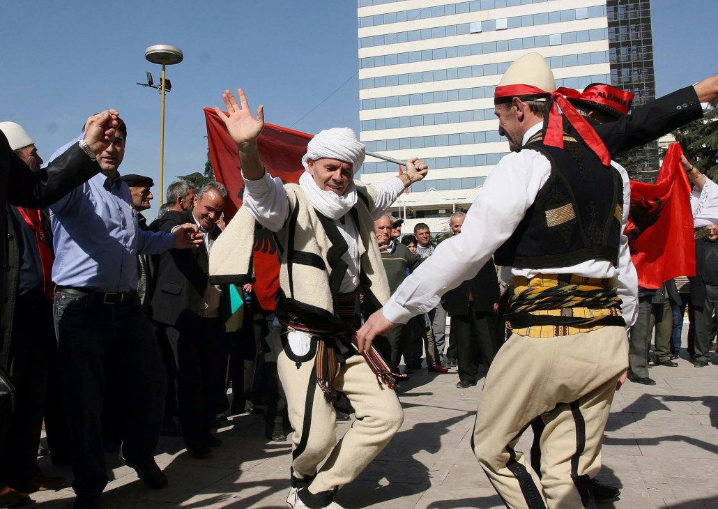 Men in traditional Albanian dress dance in celebration during Kosovo independence festivities in Tirana, Albania.