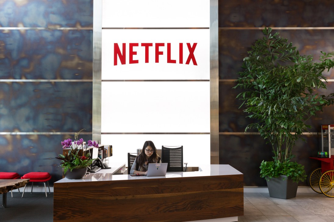 Netflix office reception in Los Gatos, Silicon Valley with employee at desk beneath large red Netflix logo
