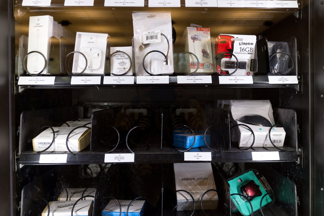 Vending machine displaying various computer cables, adapters, and tech components in organized compartments.