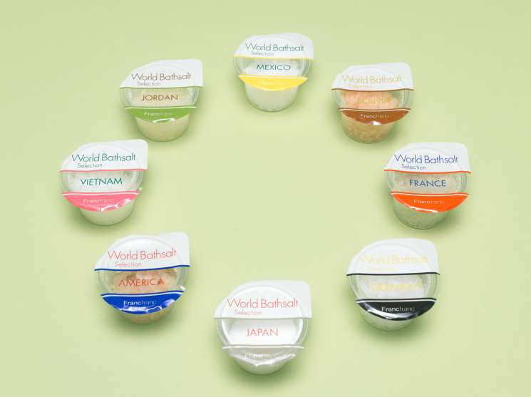 Francfranc World Bathsalt collection arranged on pale green background, featuring eight labeled bath salt containers from different countries.