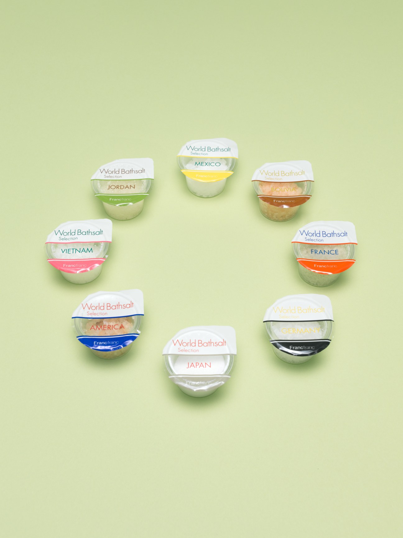 Francfranc World Bathsalt collection arranged on pale green background, featuring eight labeled bath salt containers from different countries.