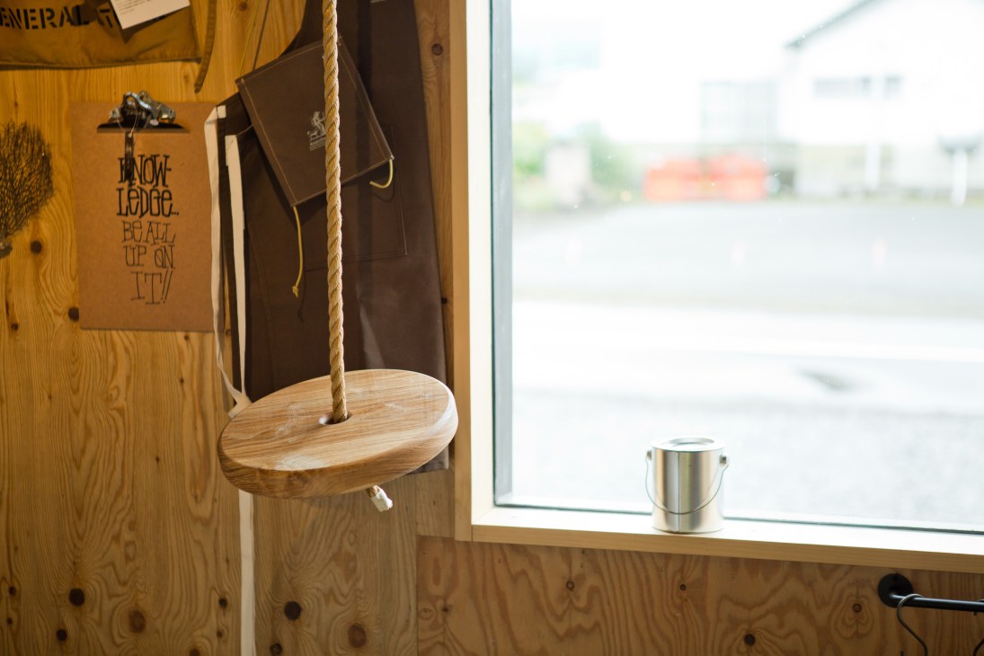 Wooden tree-swing with rope hanging on wooden wall interior at Salt shop in Hokkaido, Japan.