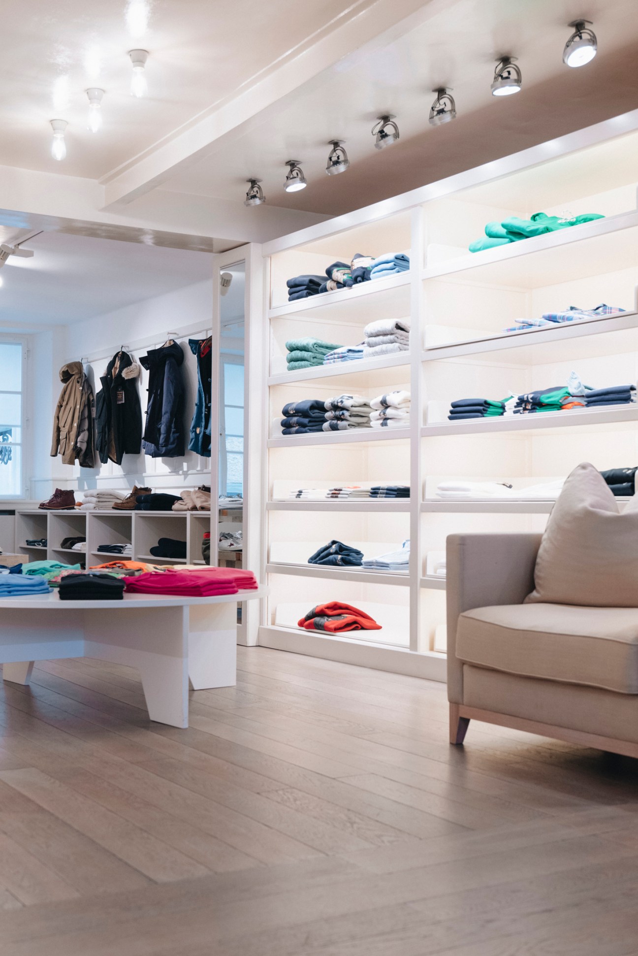 Interior of Dantendorfer clothing store with white shelving displaying folded garments and hanging clothes