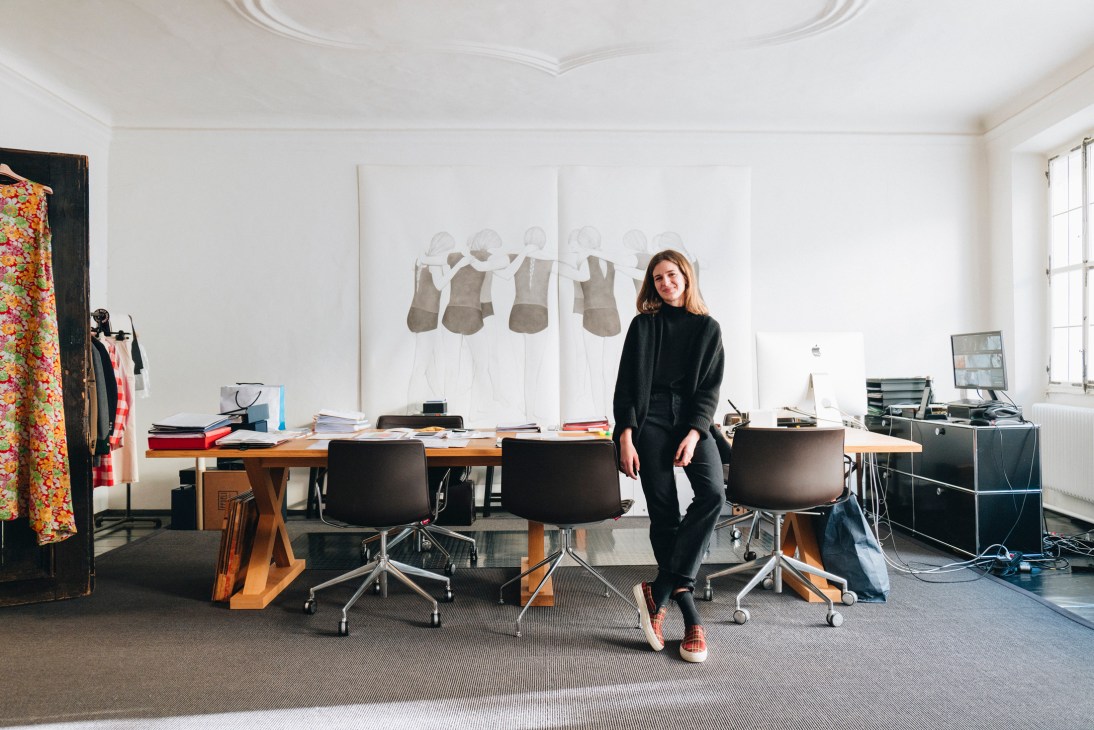 Lea Wendenburg stands in a modern office workspace with clothing displays and design materials