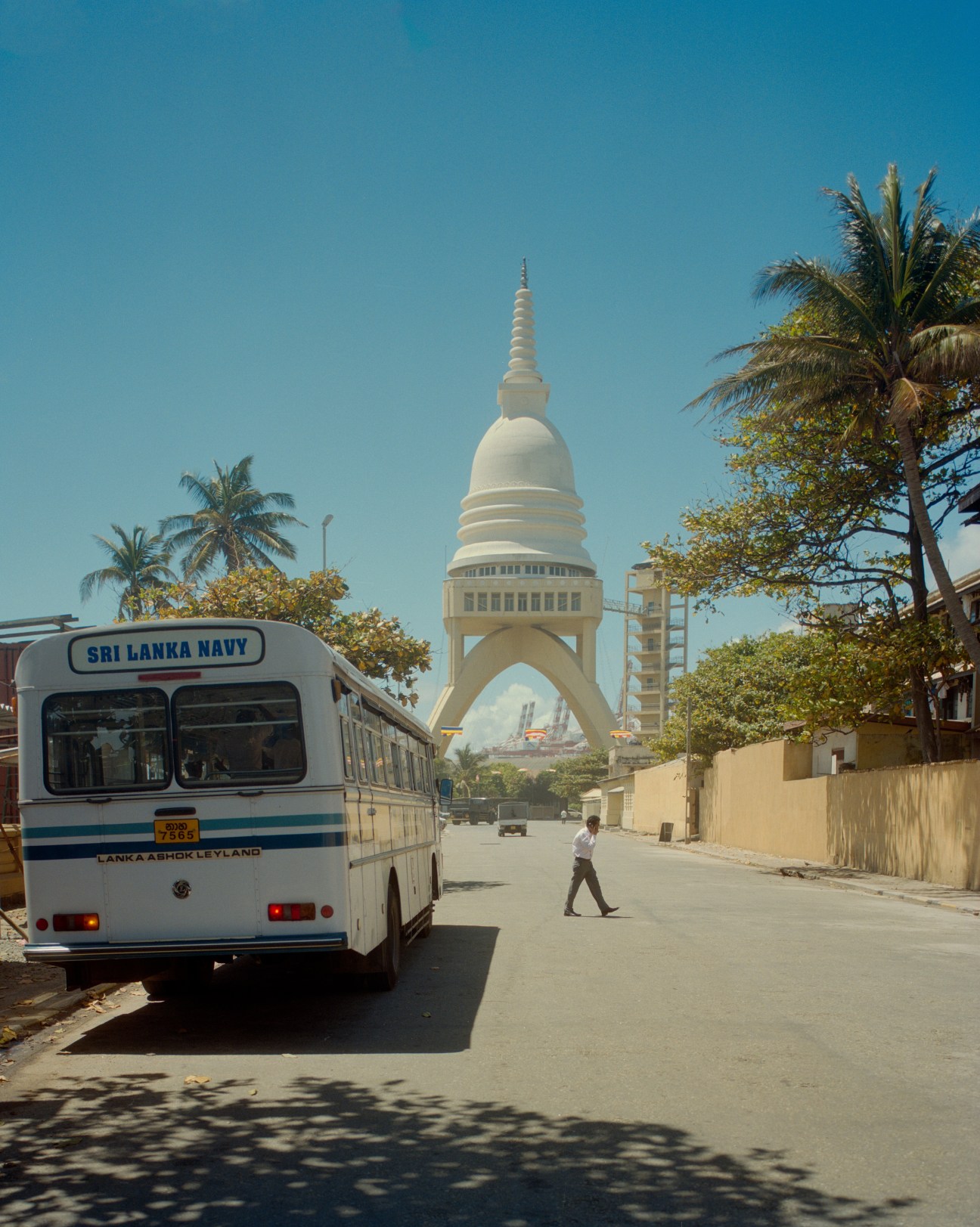 Sri Lanka Navy bus on street with white domed Sambodhi Chaithya stupa in background