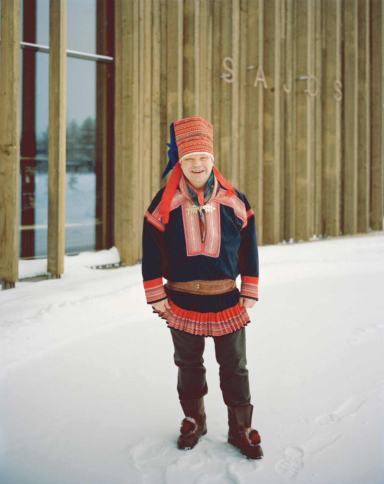 Klemetti Näkkäläjärvi, Finnish Sámi president, wearing traditional red and blue gákti dress outside the Finnish Sámi parliament building.