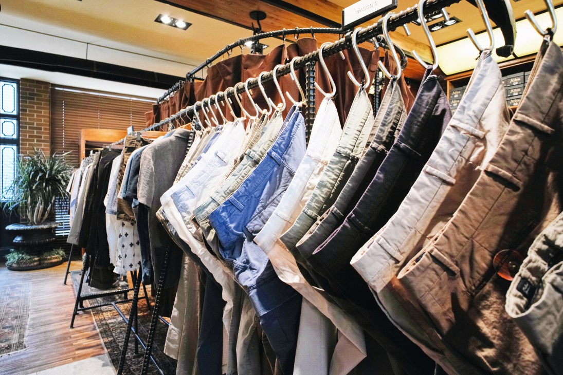 Mason's cotton trousers hung on a rack in various colors and styles at San Francisco Market shop.