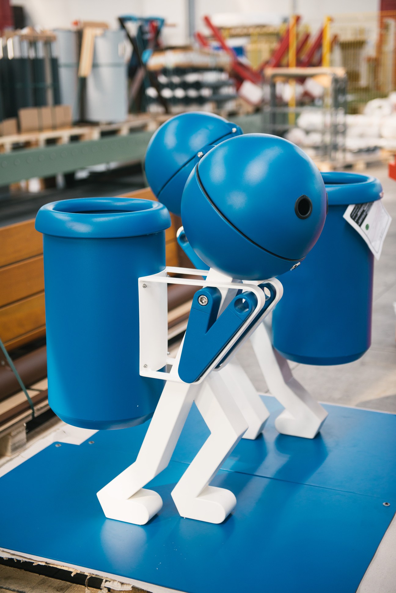 Blue and white all-in-one bike rack helmet locker and rubbish bin designed by Studiodieci in a workshop.