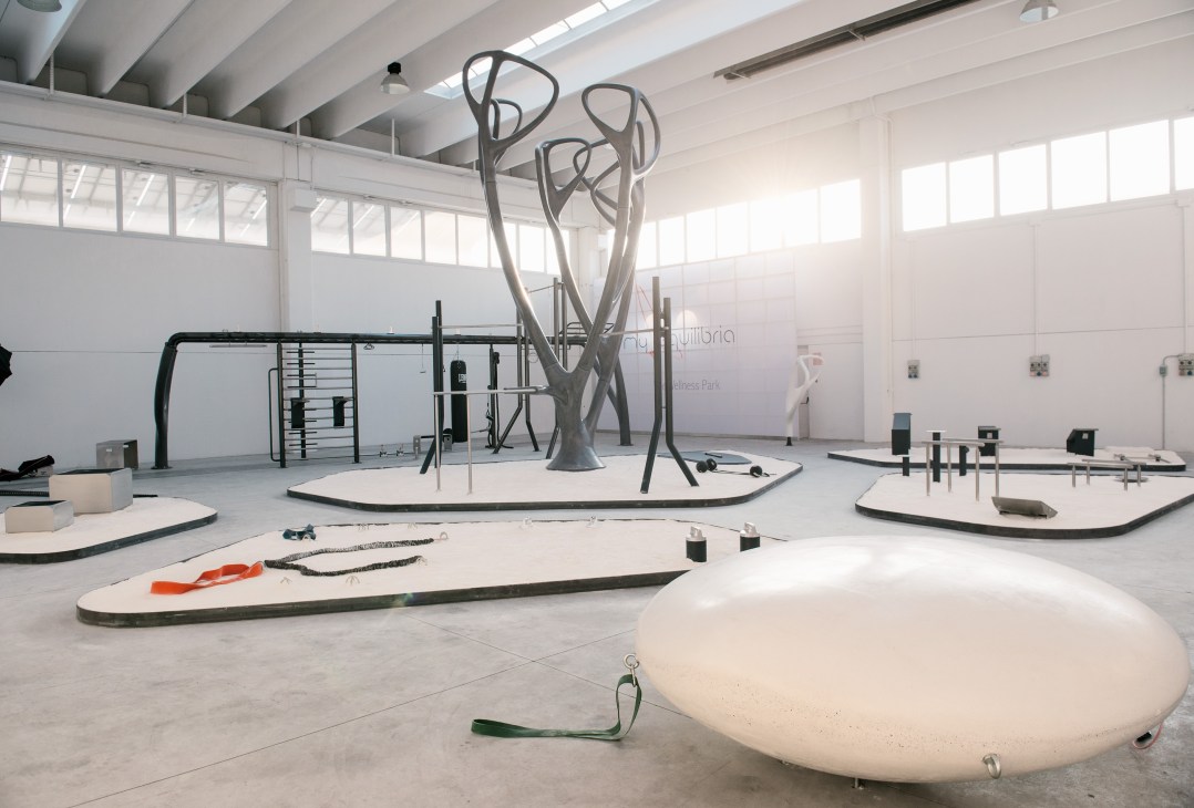MyEquilibria outdoor gym showroom with sculptural tree structure surrounded by fitness equipment islands.