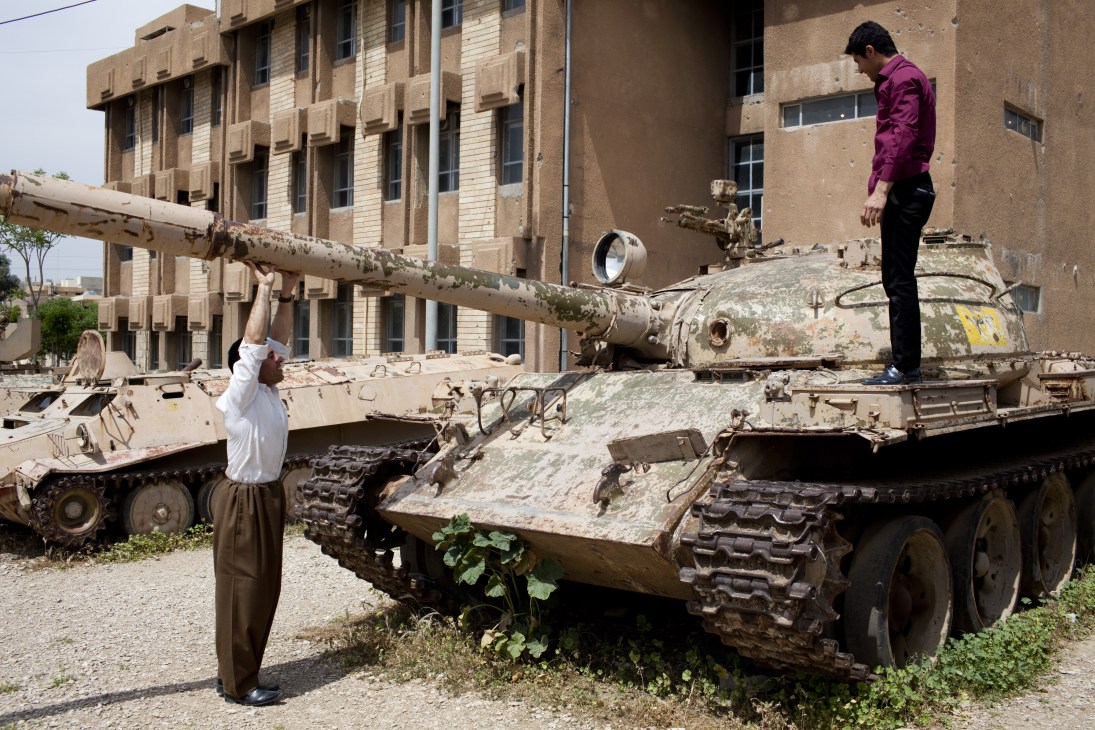 Kurdish men posing on rusted tanks captured by Kurdish guerillas in 1991 at the Amna Souraka museum in Sulaymaniyah.
