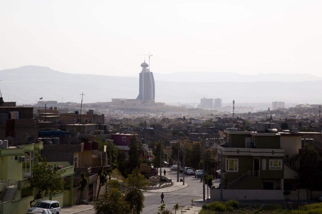 Sulaymaniyah Tower dominates the city skyline above residential buildings and mountains.