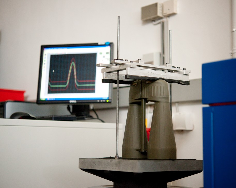 Steiner binoculars undergoing a bump test on precision equipment with computer analysis.