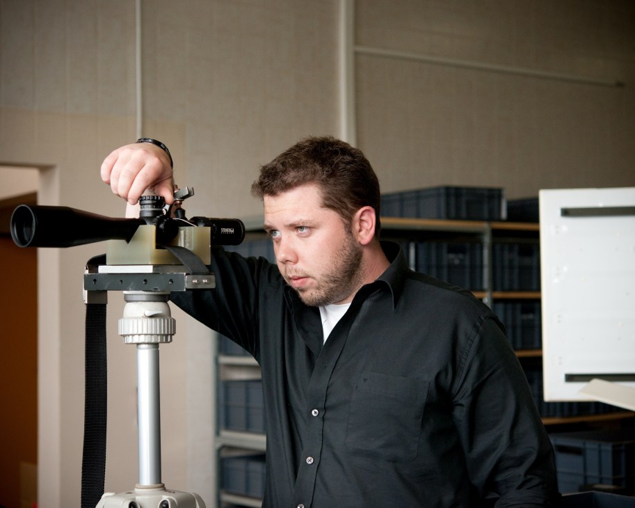 Steiner technician operating a precision CNC machine for binocular lens manufacturing.