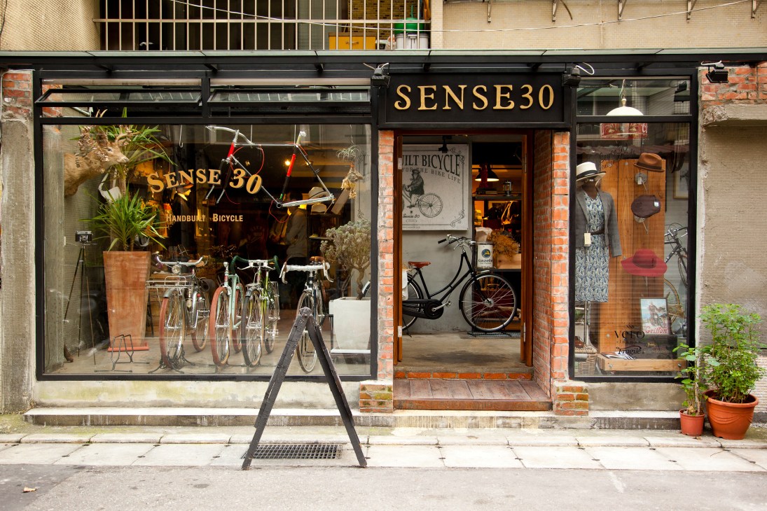 Sense30 bicycle shop storefront with handbuilt bikes displayed and cycling accessories in windows.
