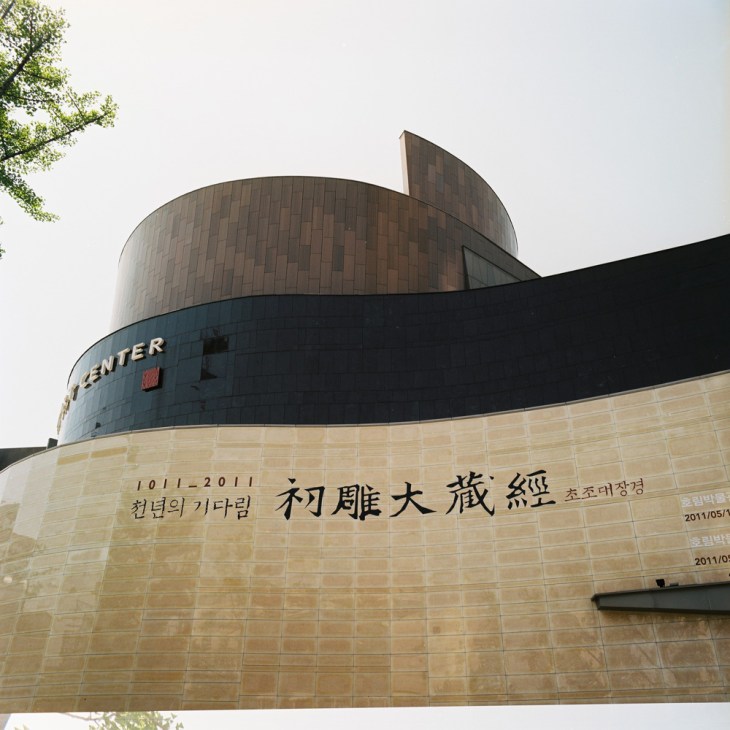 Horim Art Center's modern curved architecture with cylindrical and sail-like forms in bronze and black materials.