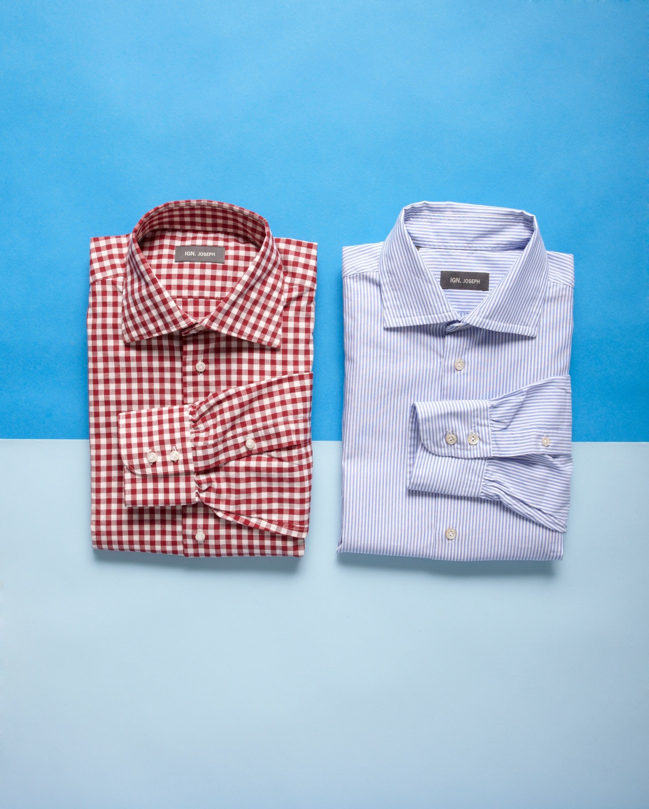 Two folded Ign. Joseph dress shirts in red gingham and blue striped patterns against a blue background.