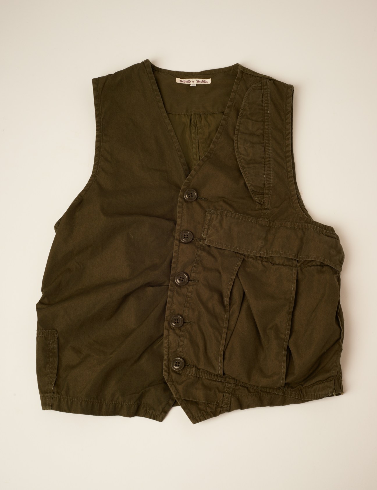 Olive-green deconstructed waistcoat made from Canadian dead-stock army trousers by Needles.