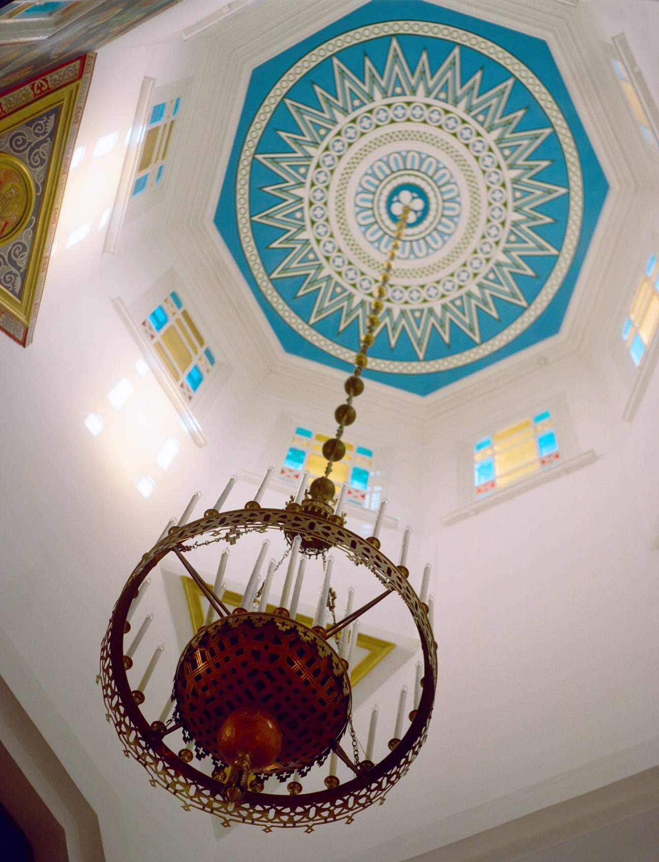 Ornate blue and gold ceiling medallion with hanging chandelier in Ascension Cathedral, Almaty.