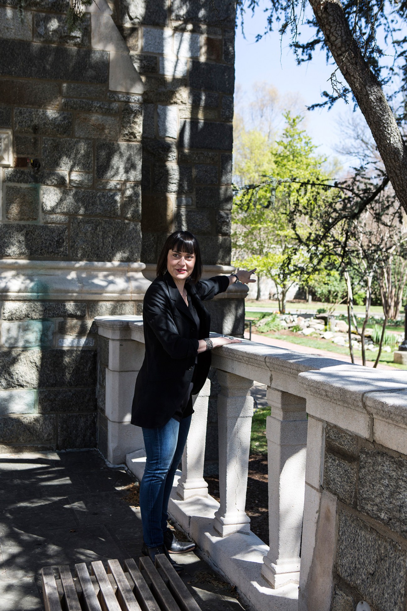 Professor Shiloh Krupar stands on a stone terrace at Georgetown University's campus on a sunny day.