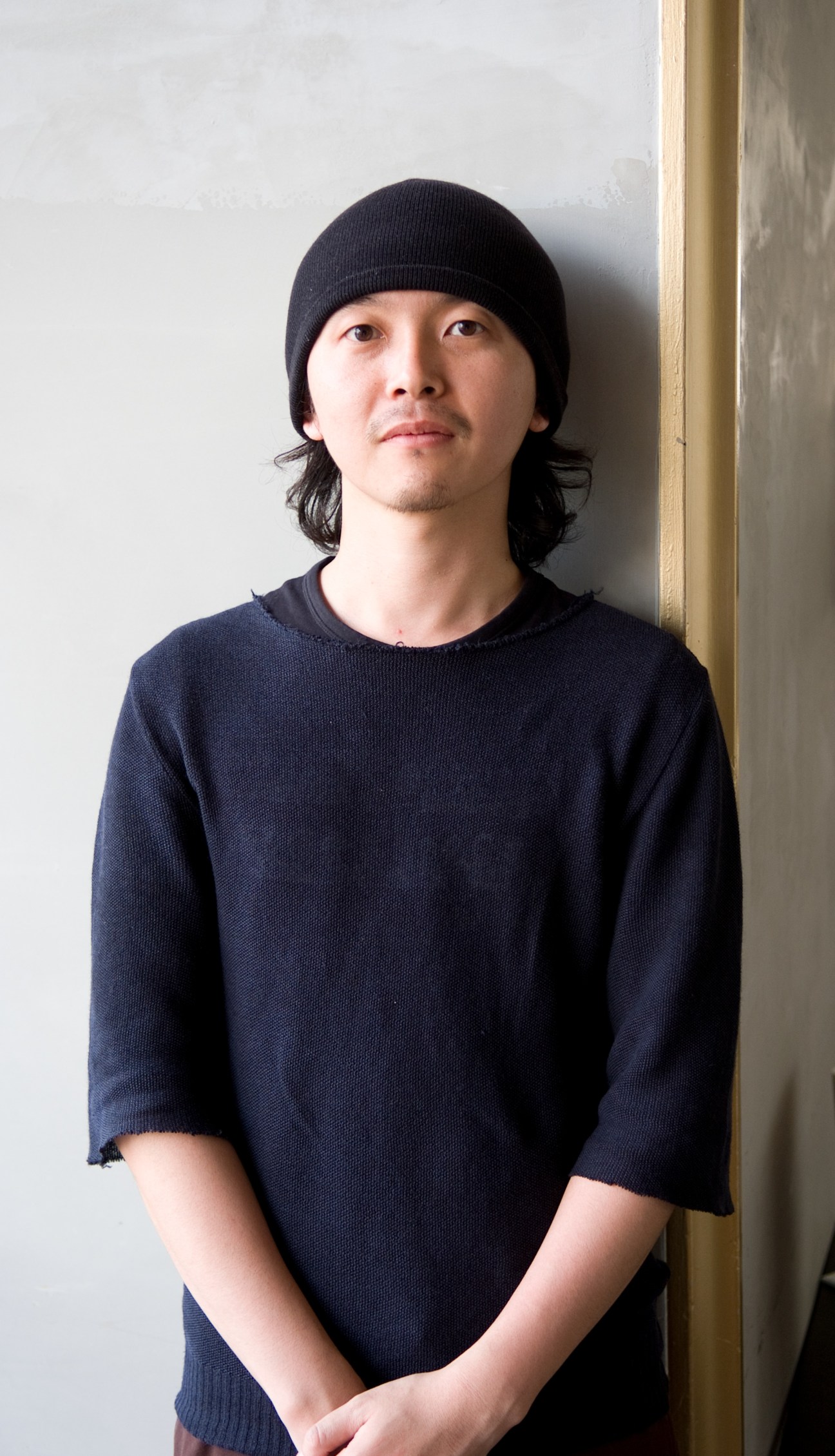 Shinji Takemura, manager of Comment Allez Vous café and bar, wearing a black beanie and dark sweater.